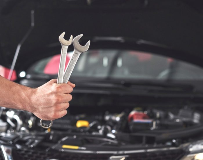 mechanic-holding-pair-wrenches-repair-garage